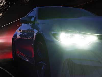 Auto fährt mit hellen Scheinwerfern durch die Nacht